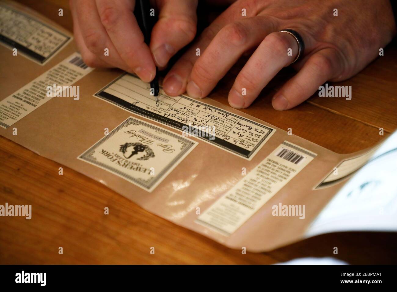 Hand writing the label for the whiskey bottle.Leiper's Fork Distillery.Franklin.Tennessee.USA Stock Photo