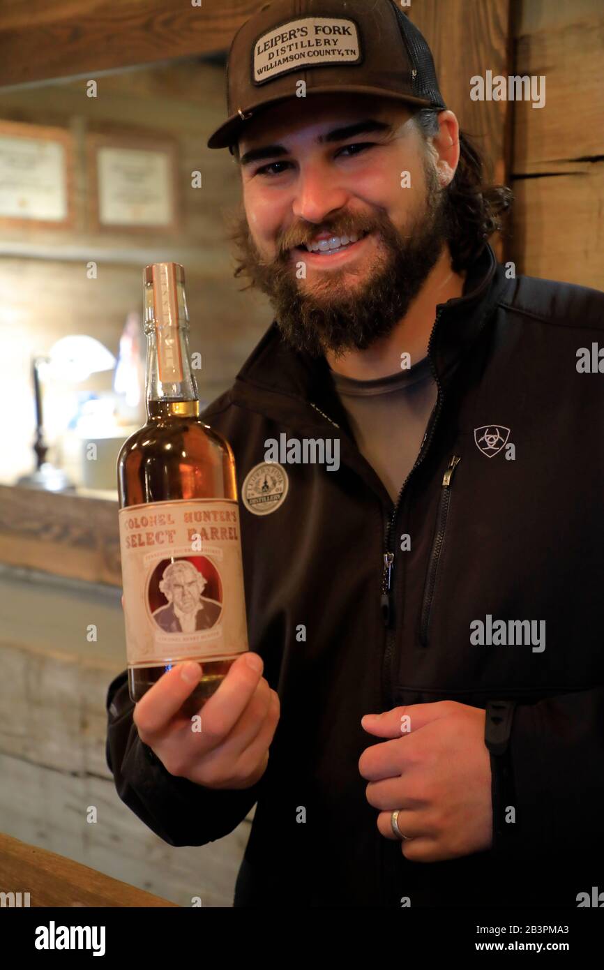 Tour guide holding a bottle of whiskey in the tasting room of Leiper's Fork Distillery.Franklin.Tennessee.USA Stock Photo