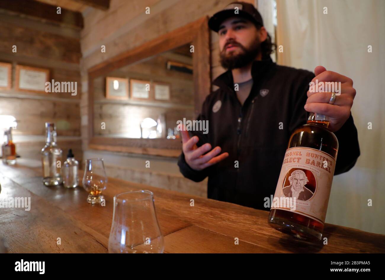 Tour guide holding a bottle of whiskey at a tasting session inside the tasting room in Leiper's Fork Distillery.Franklin.Tennessee.USA Stock Photo