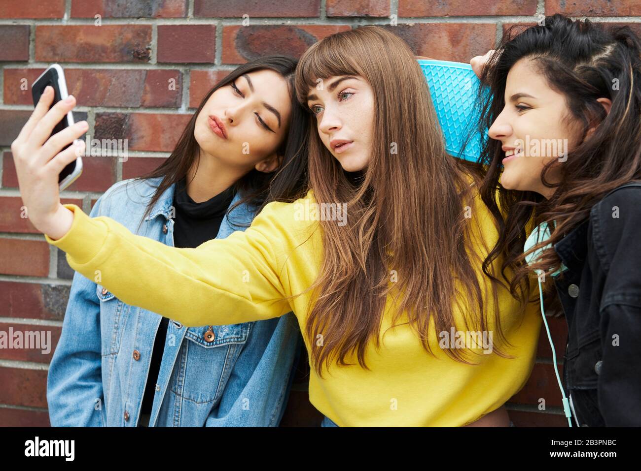 Three girls making a selfie by mobile phone Stock Photo