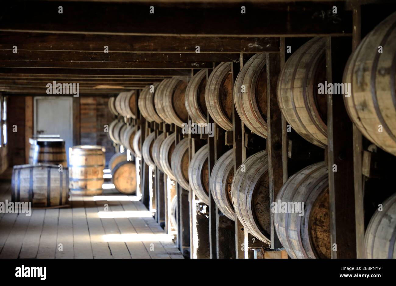Whiskey barrels stored in traditional warehouse rack house in Barton