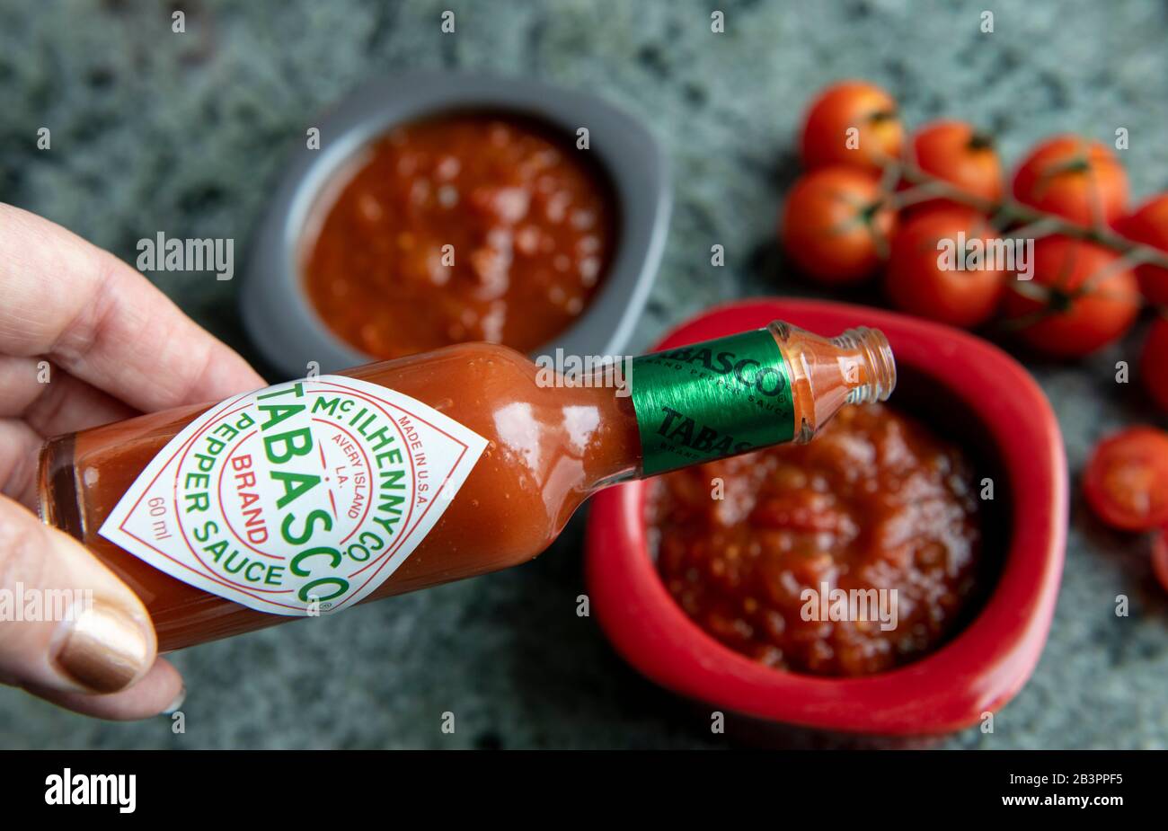 Spice up your salsa.Adding Tabasco Pepper sauce to tomato salsa.Hong Kong,China:05 Mar,2020. Stock Photo