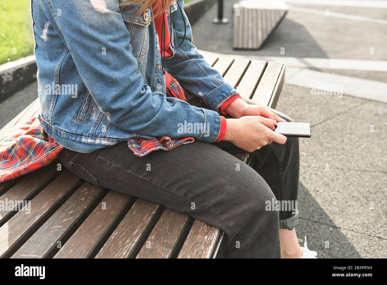 Side view of young woman with mobile phone Stock Photo