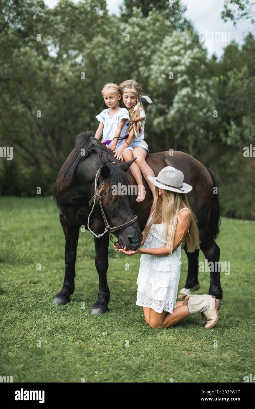 Happy family mother with two children cute daughters riding a