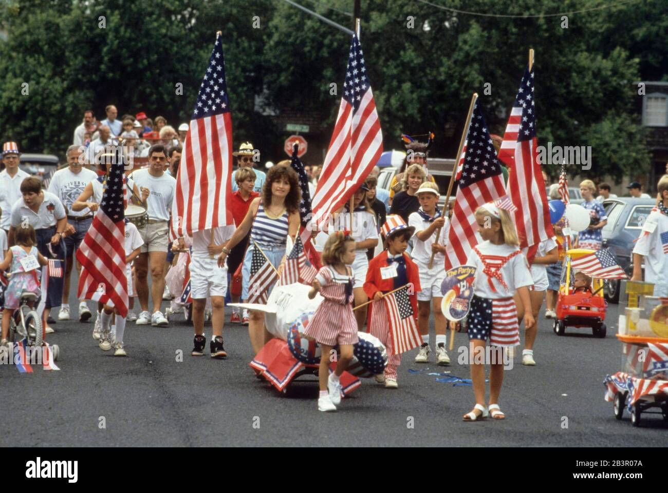 Austin, Texas USA, July 4 1989: Parents and children walk in a small neighborhood parade celebrating American Independence Day on the Fourth of July. ©Bob Daemmrich Stock Photo