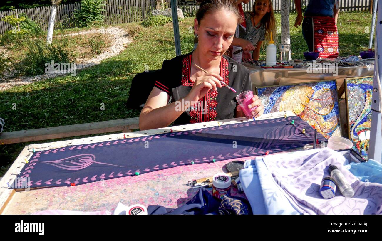 Ethnographic Open Air Museum 'Etar', Gabrovo, Bulgaria. September 6, 2019 International Fair of Traditional Crafts. Bulgarian artist paints on silk. Stock Photo
