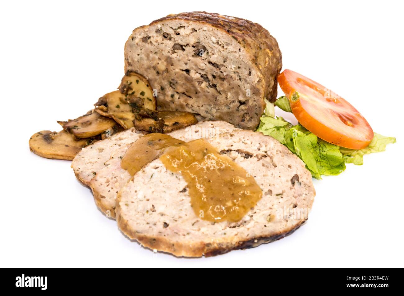 Meatloaf cut into slices with mushrooms, tomato and salad on an isolated white background. Stock Photo