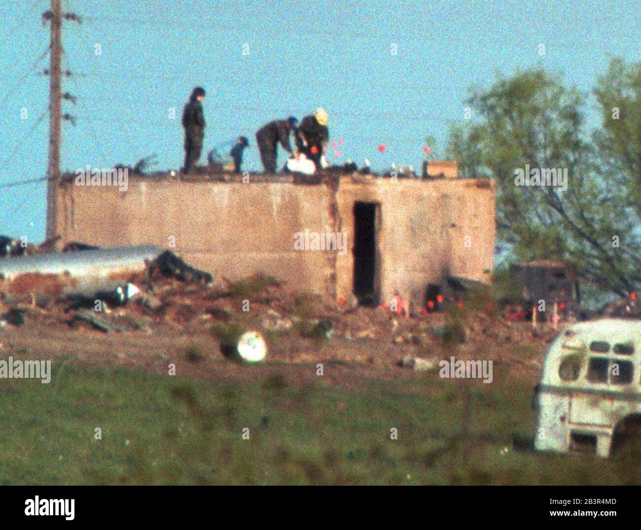 Waco Texas USA, 23APR1993: Federal agents fill body bags on top of the burned-out ammunition bunker at the Branch Davidians' Mount Carmel Center property after the religious sect's compound burned four days earlier. The fire killed 76 members of the group and ended a 51-day siege between the group and federal law enforcement agents near Waco. ©Bob Daemmrich Stock Photo
