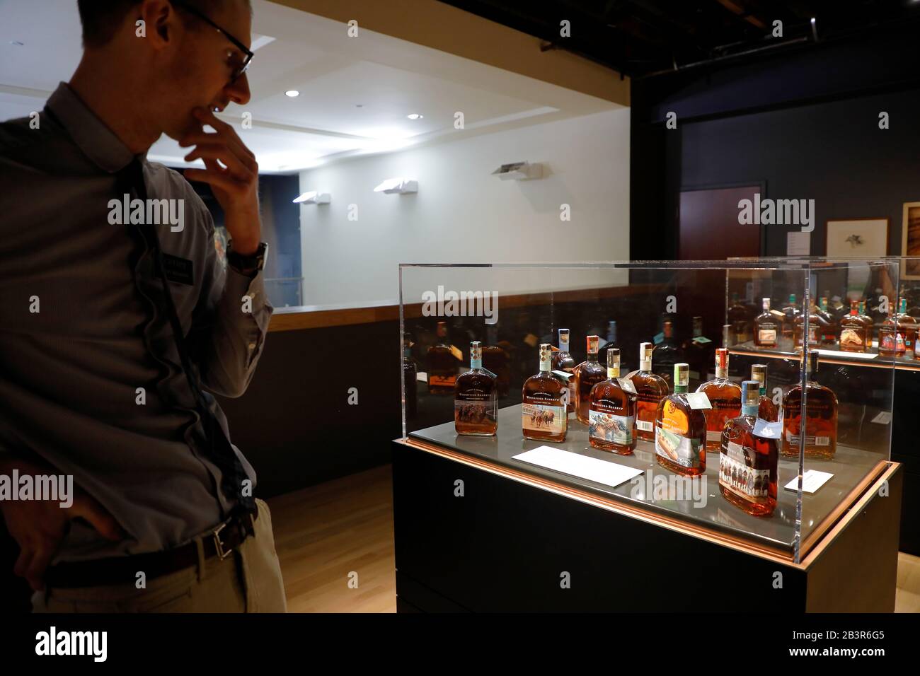 Man looking at the collection of Woodford Reserve & the Kentucky Derby special edition Bourbon Whiskey in the Frazier History Museum.Louisville.Kentuc Stock Photo