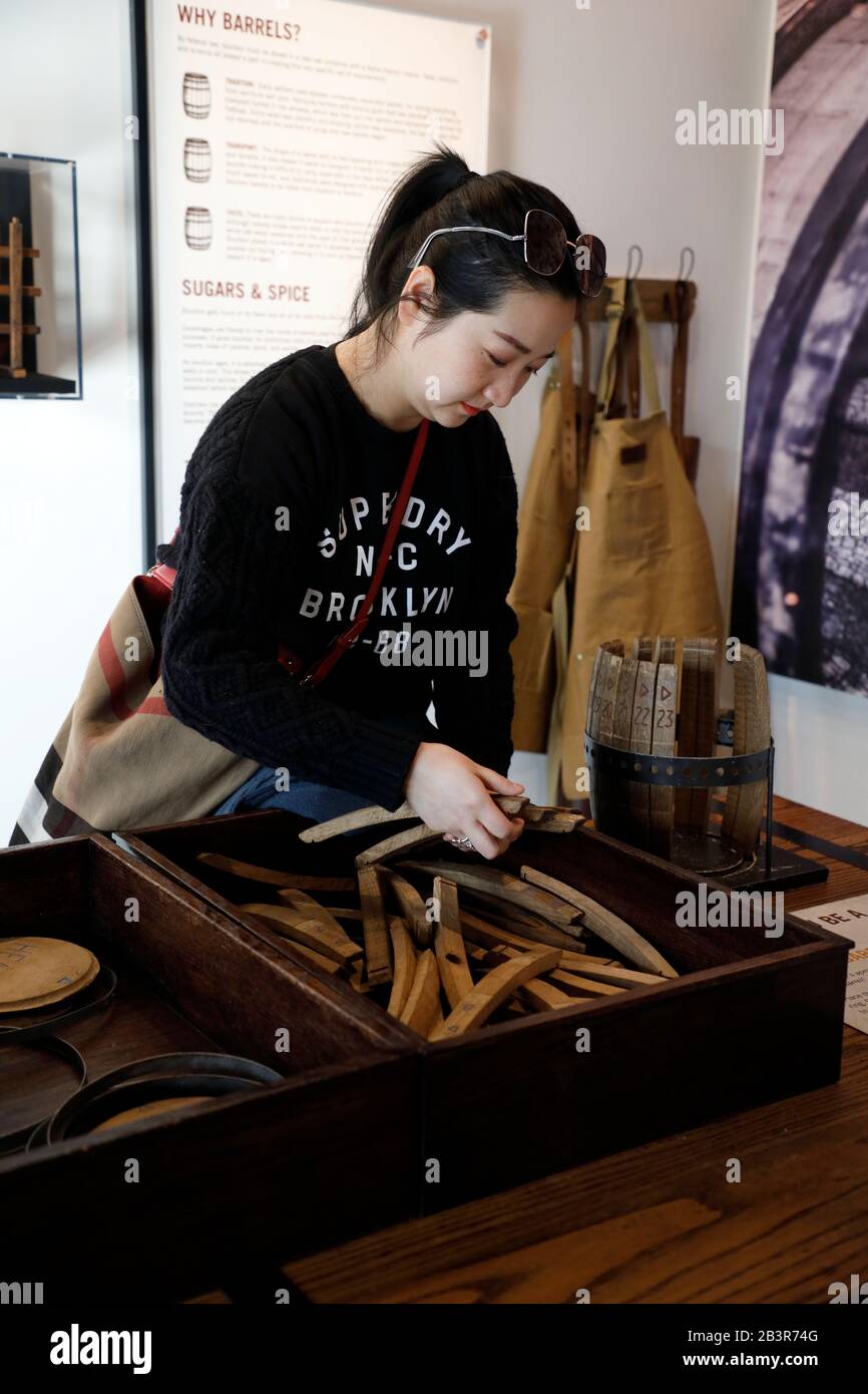 A female visitor learning to make a Bourbon Whiskey barrel model in the Frazier History Museum.Louisville.Kentucky.USA Stock Photo