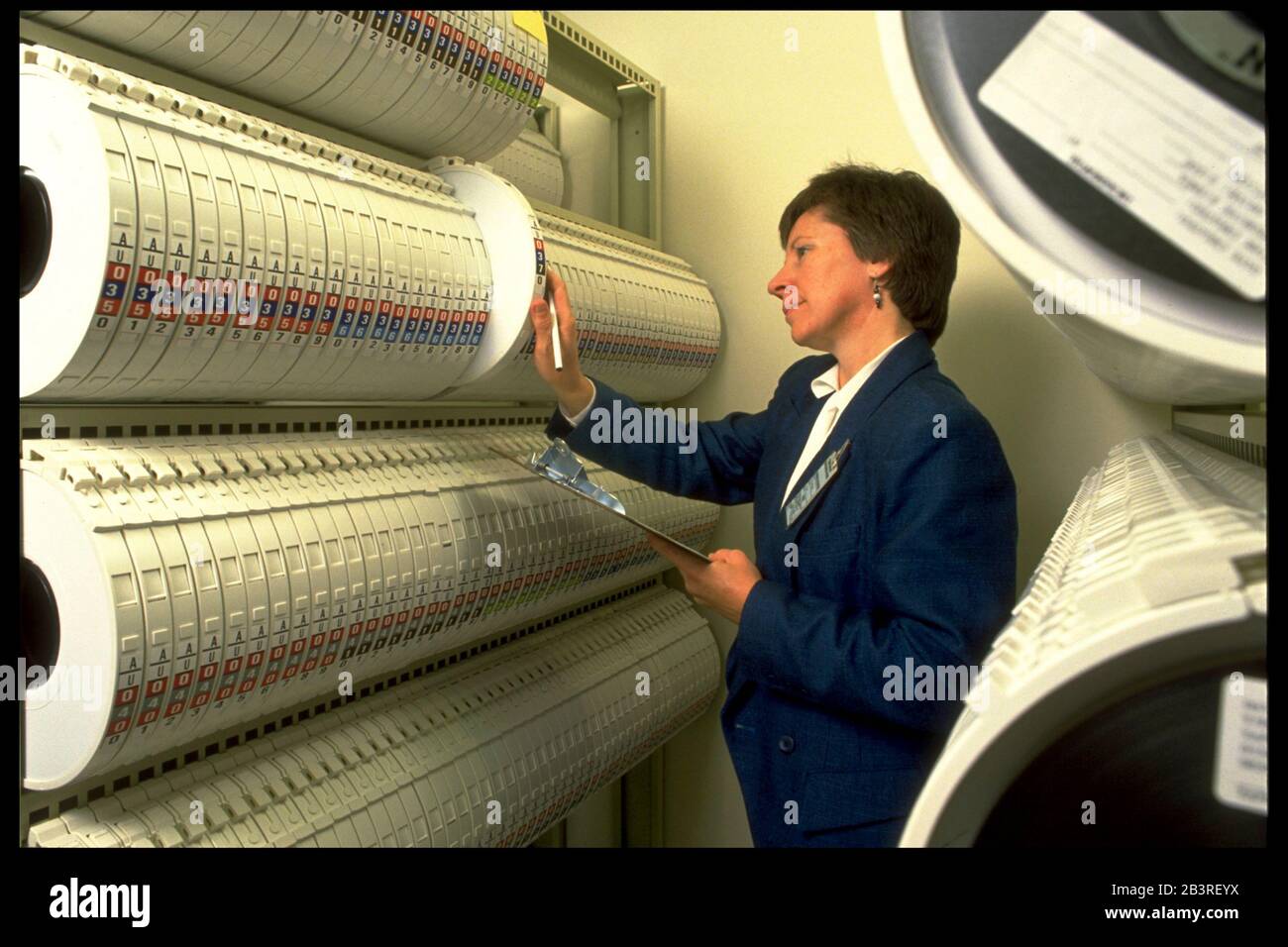 Austin Texas USA, 1990: Clerk looks at racks of magnetic tapes storing data compiled at the United States Census regional data processing center. ©Bob Daemmrich Stock Photo