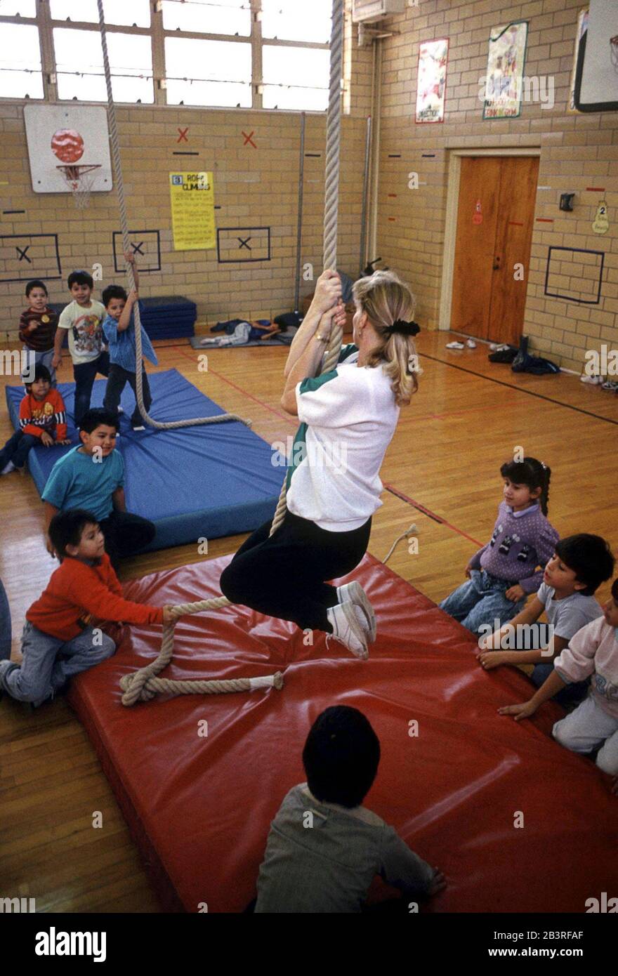 Austin, Texas USA, circa 1989: Physical education teacher demonstrated rope  climbing to kindergarten students during gym class at Metz Elementary  School. ©Bob Daemmrich Stock Photo - Alamy