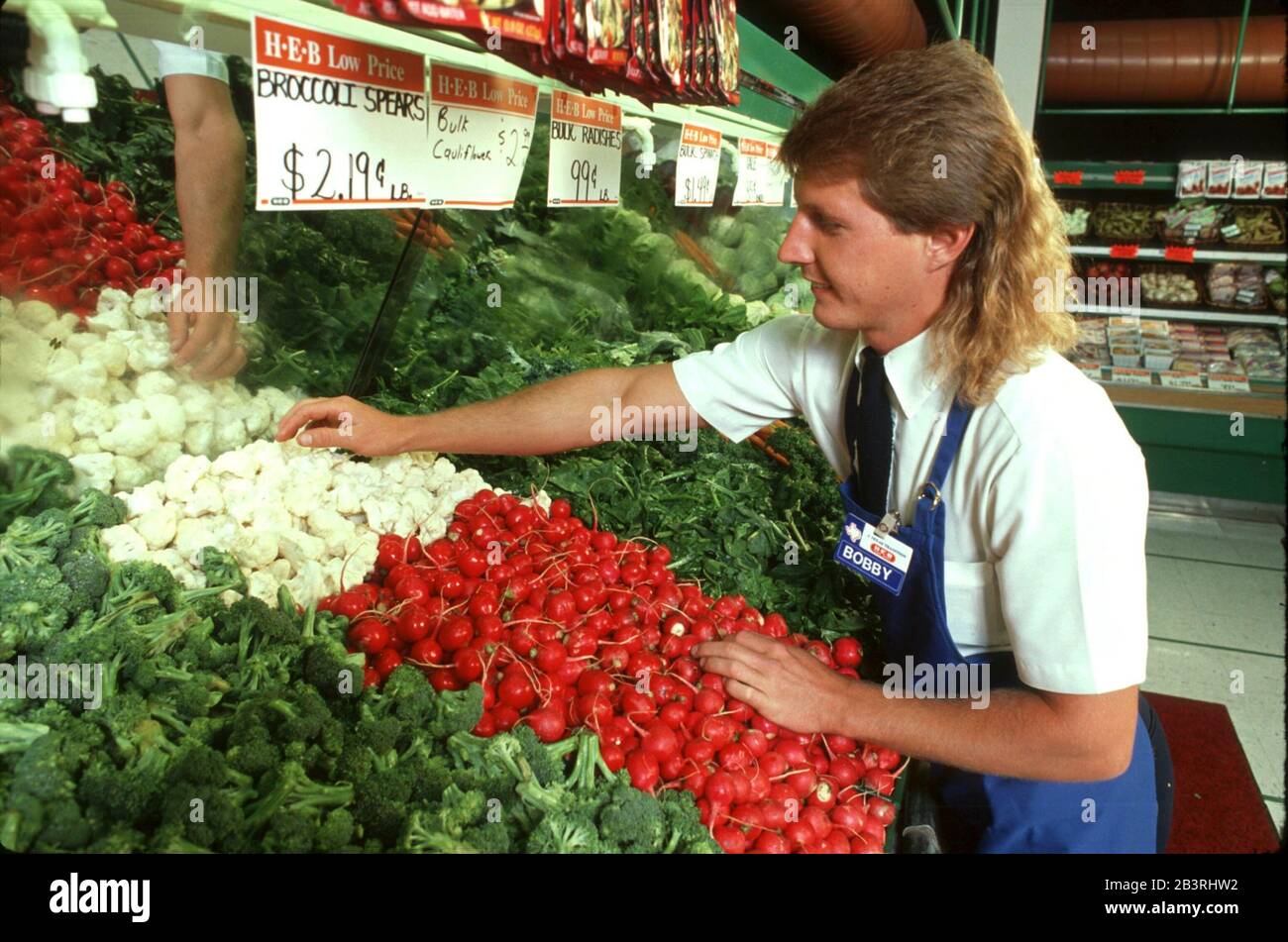 Austin Texas USA, circa 1992 Young male produce clerk tidies up