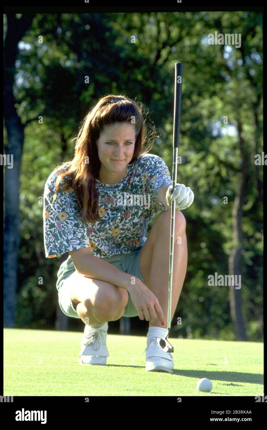 Austin Texas USA: Female golfer lines up her putt on the green at a municipal golf course.  ©Bob Daemmrich Stock Photo