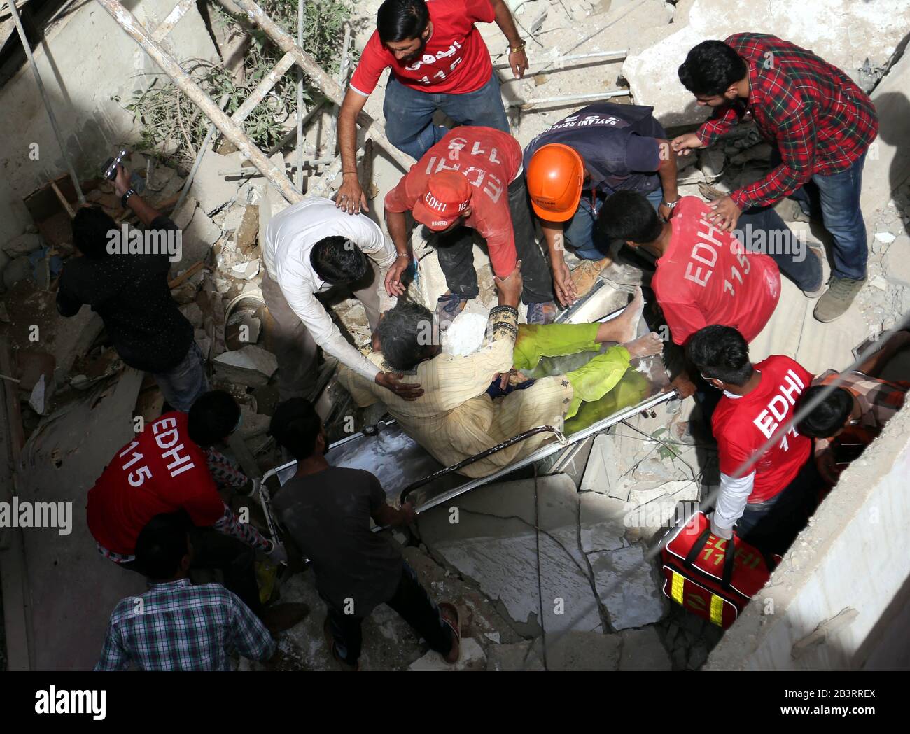 Karachi. 5th Mar, 2020. Volunteers rescue an injured woman from the rubble of a collapsed residential building in southern Pakistani port city of Karachi on March 5, 2020. A five-story residential building in Pakistan's southern port city of Karachi collapsed on Thursday, leaving at least three people killed and multiple others trapped, said rescue and medical officials. Credit: Str/Xinhua/Alamy Live News Stock Photo