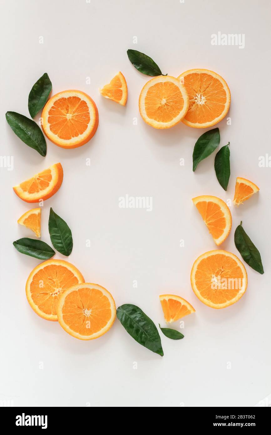 Orange slices and leaves styled in a circle on a white background with a copy space Stock Photo
