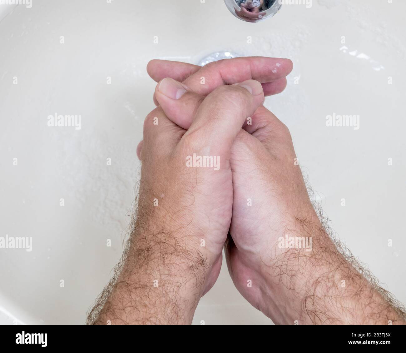 Man washing hands close-up from above, one of several handwashing steps ...