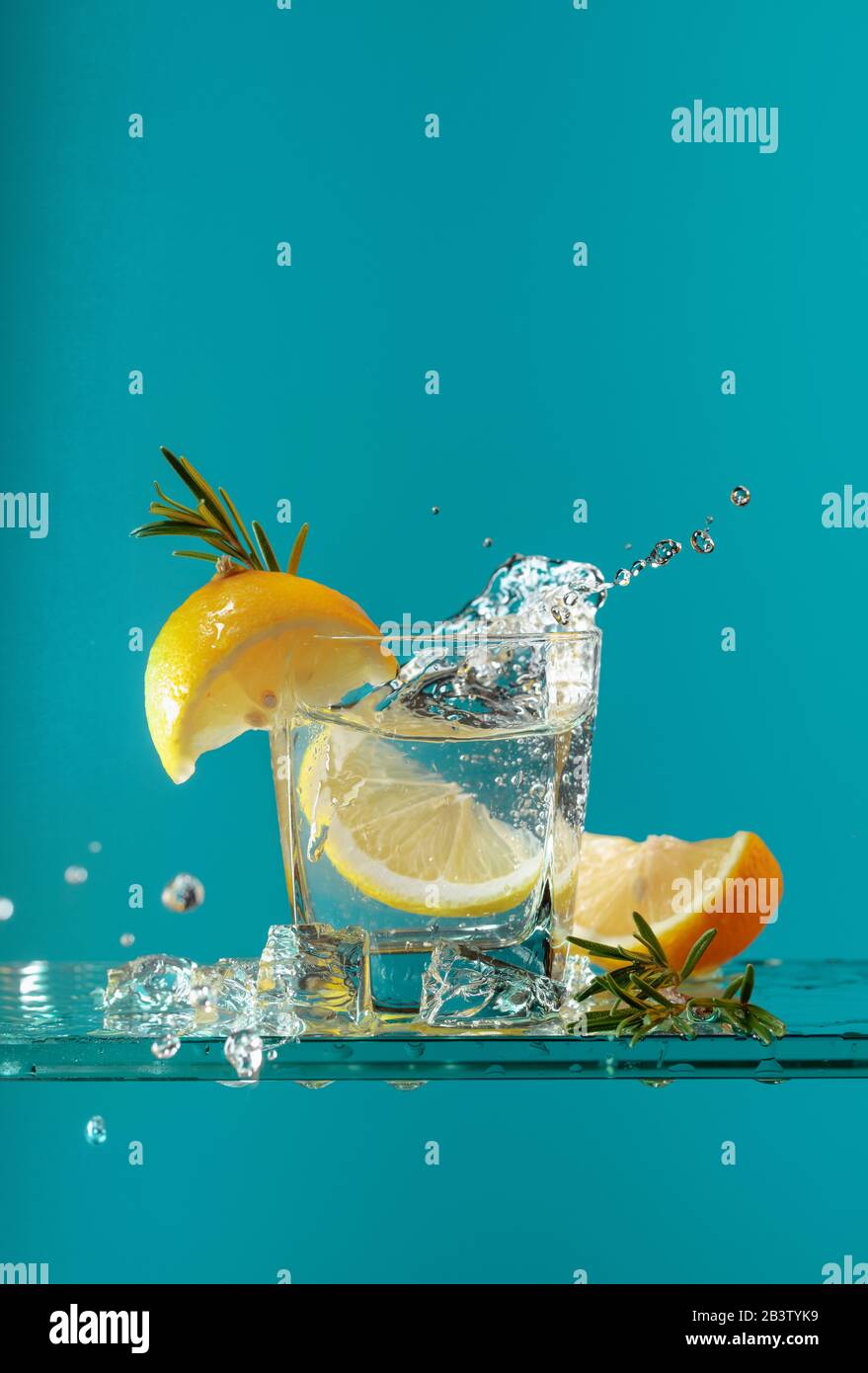 Cocktail gintonic with lemon and rosemary. Carbonated drink with ice