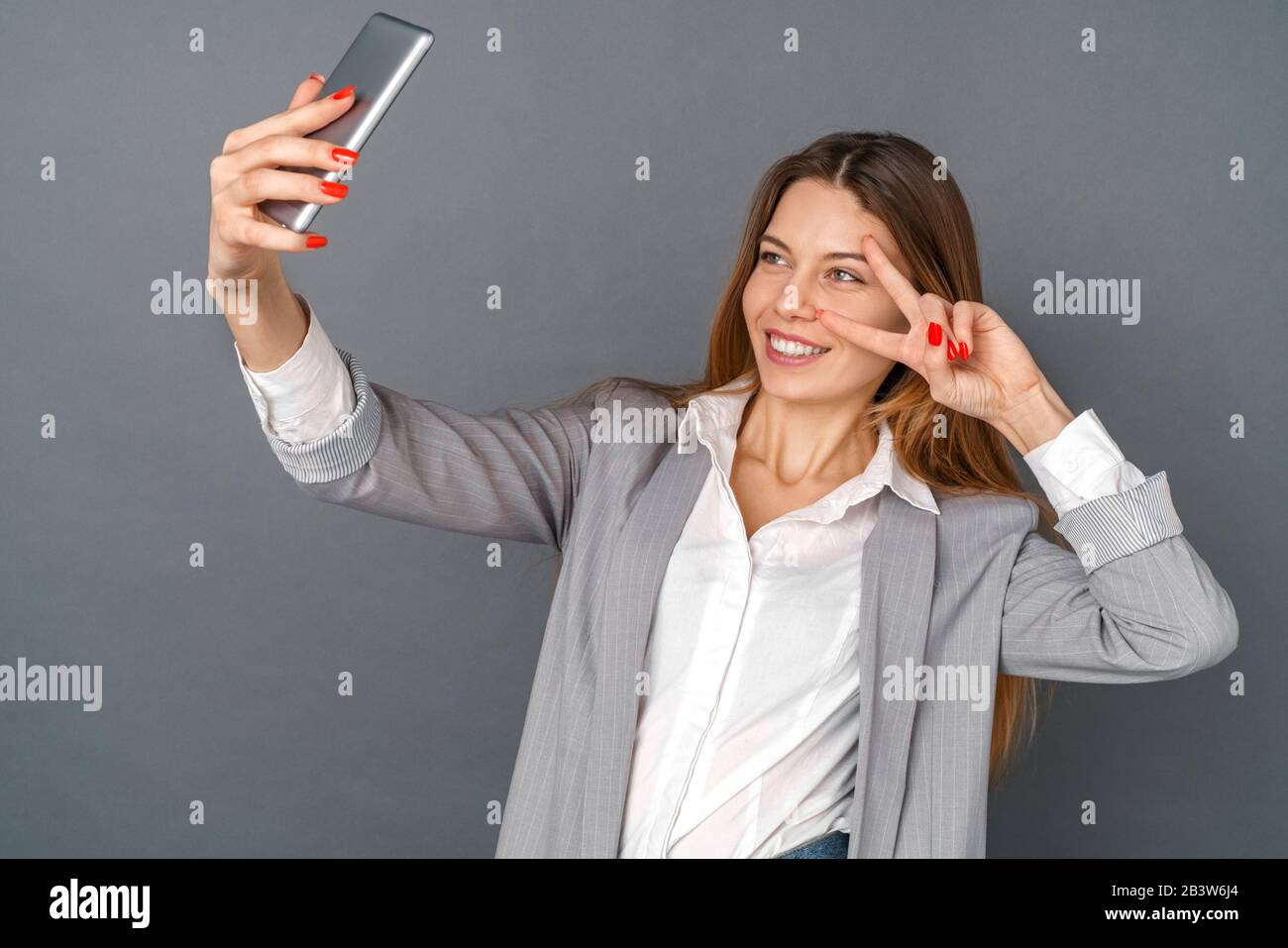 Young business woman studio isolated on gray taking selfie pictures happy Stock Photo
