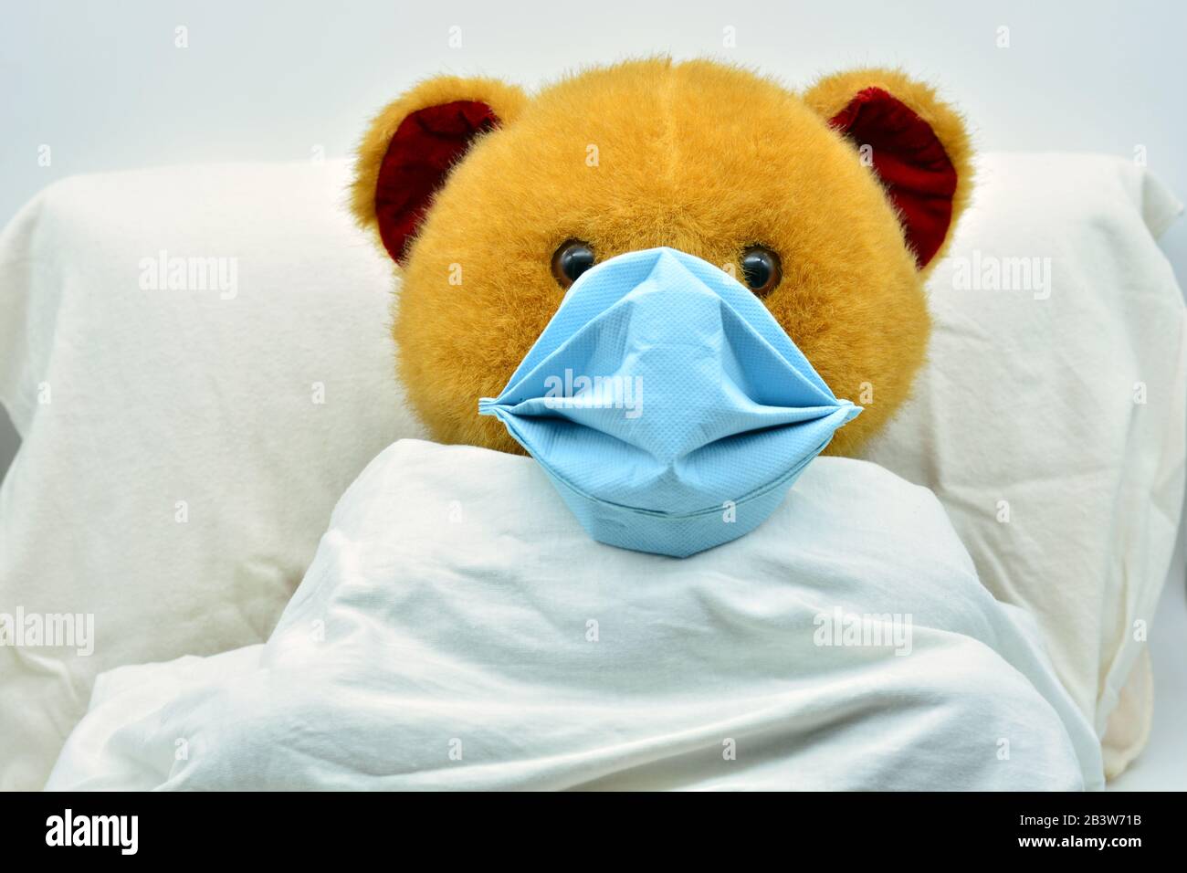 teddy bear with a mask, sick of coronavirus in a hospital bed Stock Photo