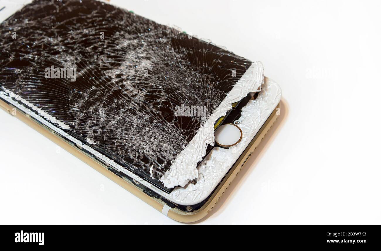 Modern smartphone with highly broken screen isolated on white background. Stock Photo