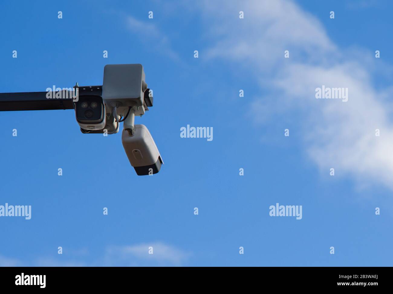 Surveillance cameras in front of blue sky Stock Photo