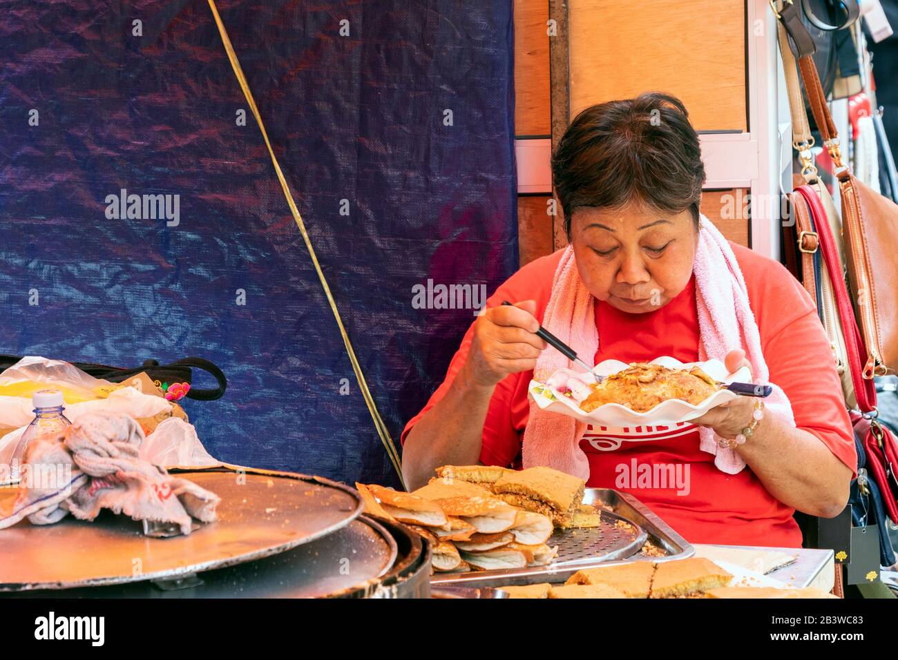 Local oriental woman having lunch at the Chinese market, Chinatown, Kuala Lumpur, Malaysia, Asia Stock Photo