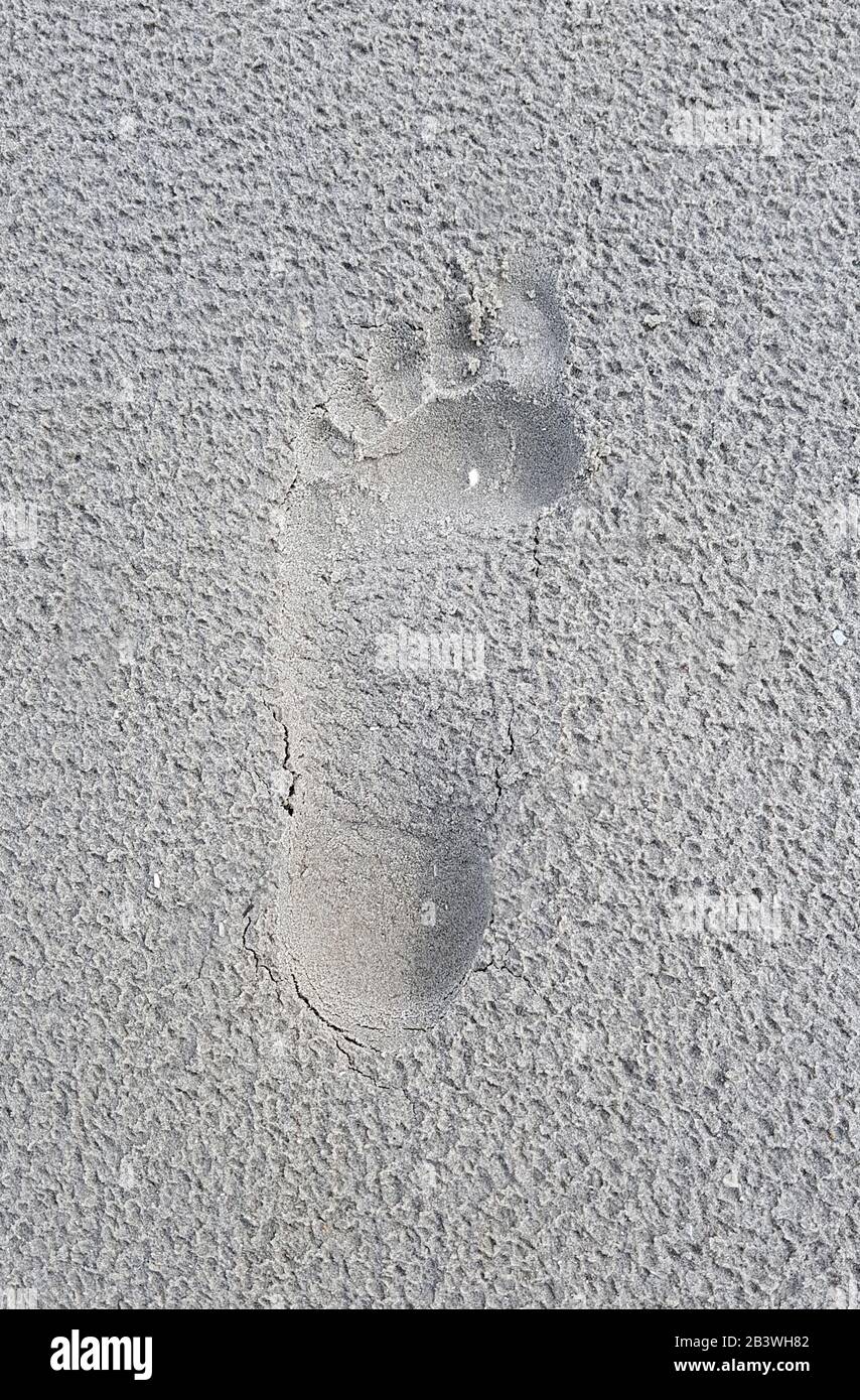 Fussabdruck eine menschlichen Fusses im Sand. Footprint of a human foot in the sand. Stock Photo