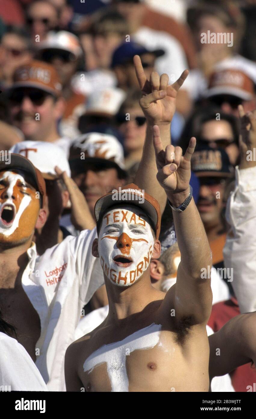 Austin Texas USA, 1993: University of Texas at Austin fans with painted faces cheer for their team at football game. ©Bob Daemmrich. Stock Photo
