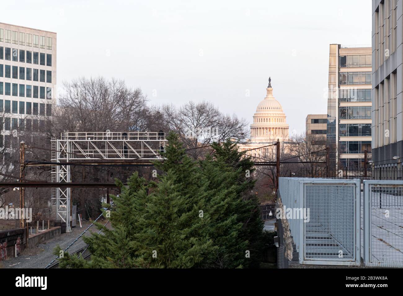 The US Capital Building Dome peaking out in the distance viewed from above a railroad line that runs through Washington, D.C. Stock Photo