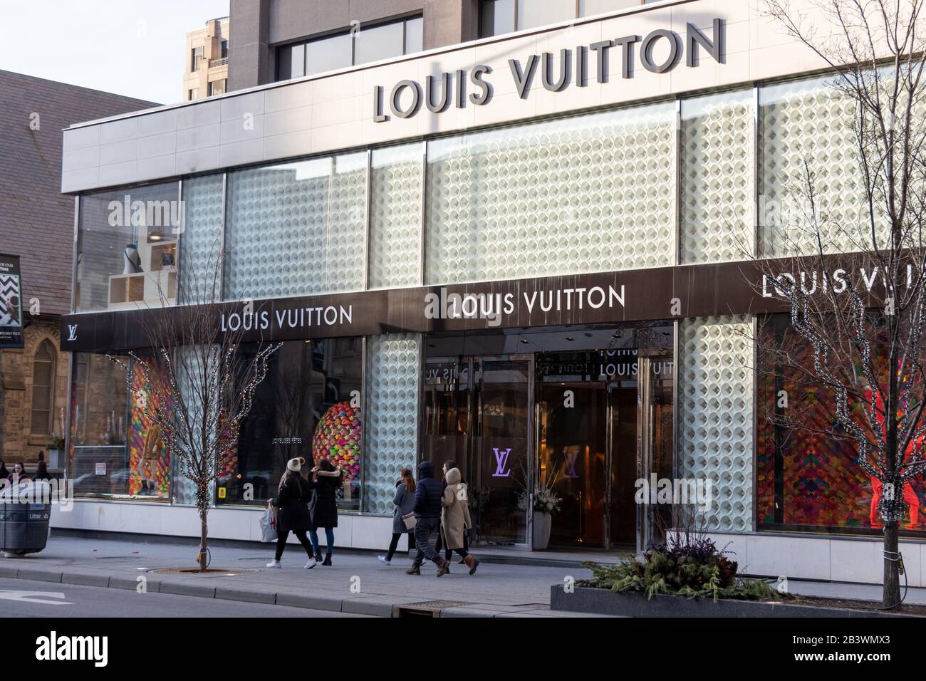 Louis Vuitton store in downtown Toronto seen as people walk by on a sunny late afternoon. Stock Photo