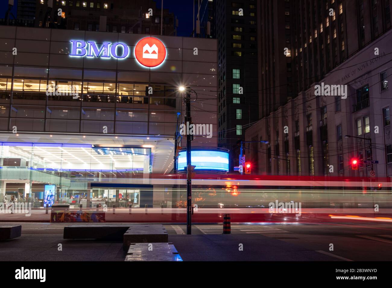Bank of Montreal (BMO) sign atop of their branch at the base of the First Canadian Place on a busy at night in downtown Toronto. Stock Photo