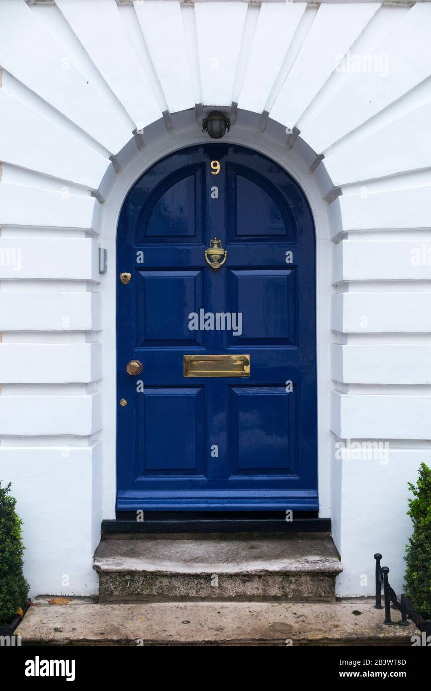 Bright or deep blue front door with brass door furniture and a stone