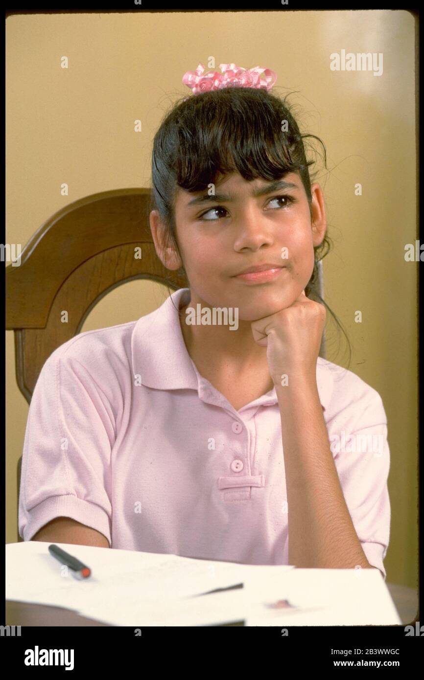 Austin Texas USA: Hispanic teen girl thinks about what she's going to write for homework assignment. ©Bob Daemmrich Stock Photo
