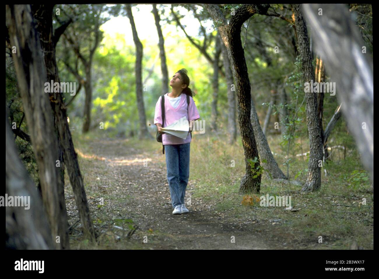 Austin Texas USA: 12-year-old Hispanic girl using map while walking on path in wooded park.  ©Bob Daemmrich Stock Photo