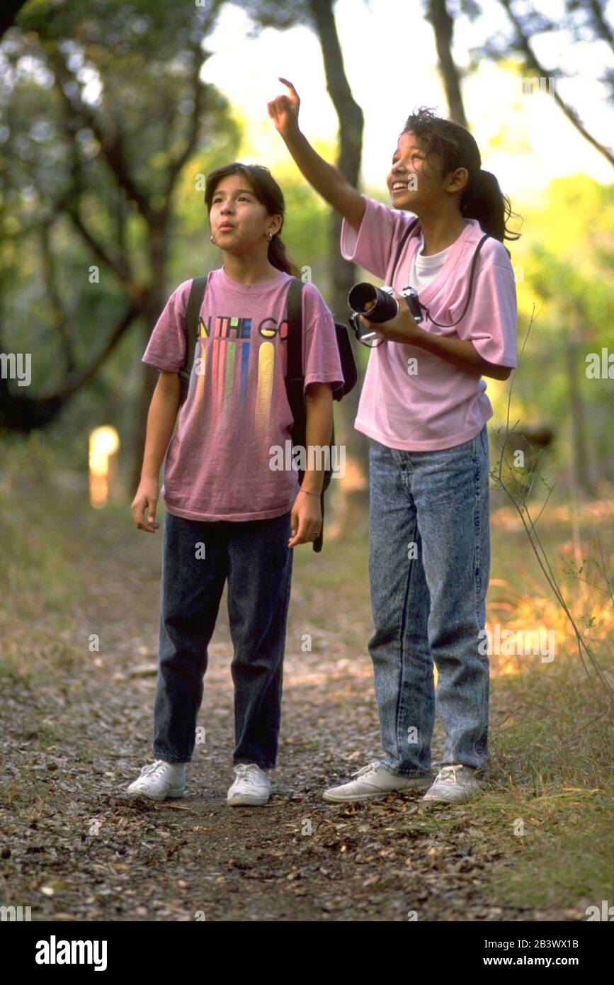 Austin Texas USA Hispanic girls birdwatching while hiking in the woods
