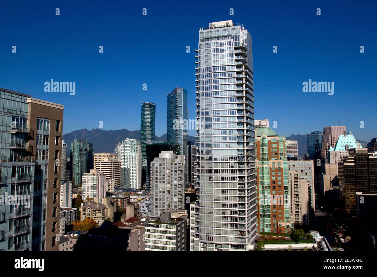 A cityscape of downtown Vancouver taken from an elevated position along Burrard Street with the north shore mountains in the background Stock Photo