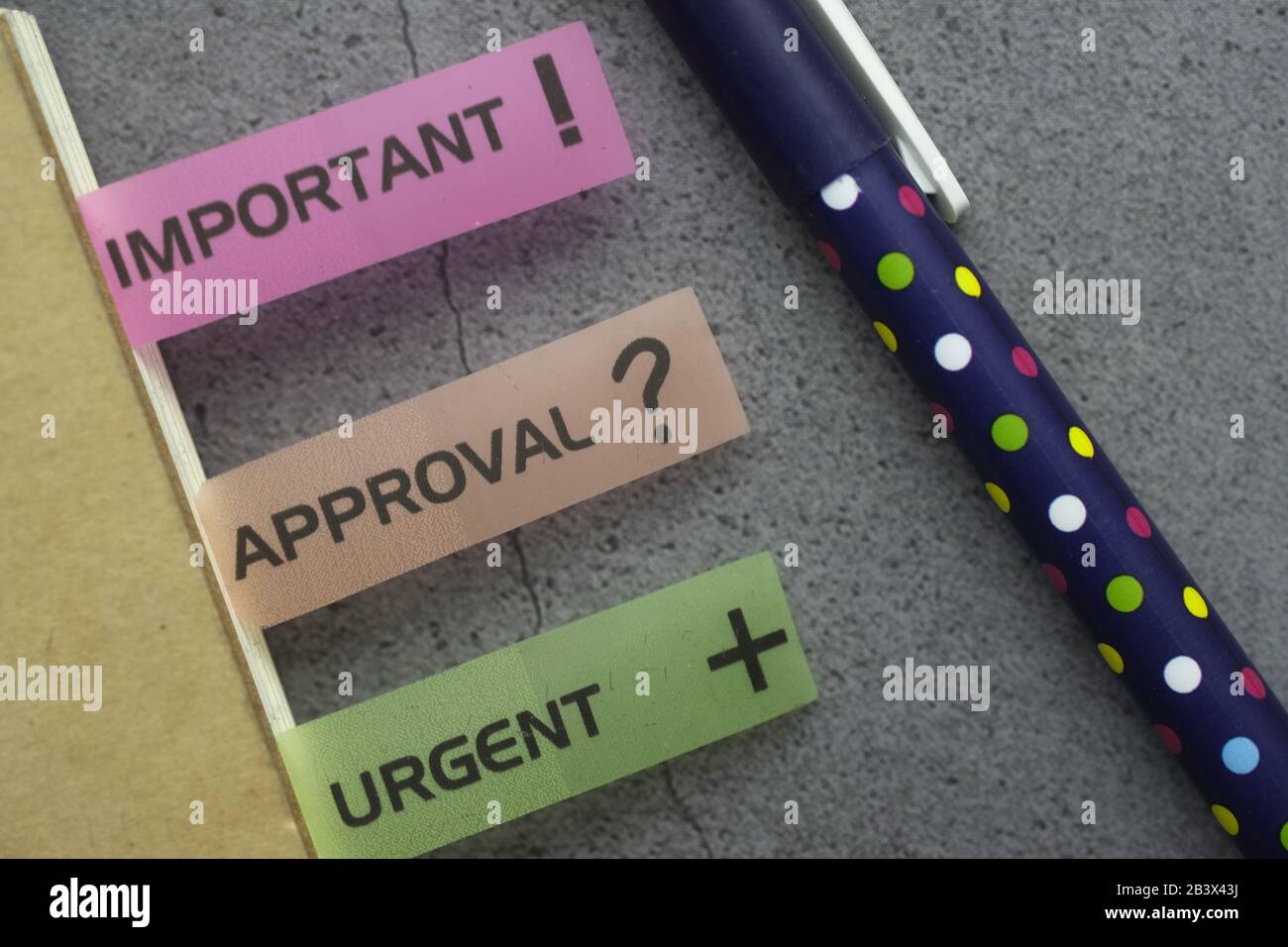 important and urgent text on notepad with pen on table  Stock Photo