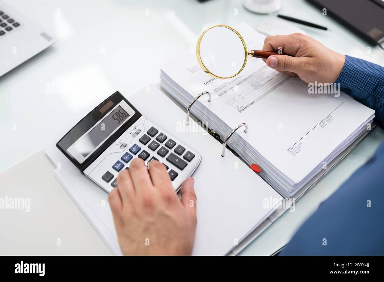Businessman Looking At Document Through Magnifying Glass Stock Photo