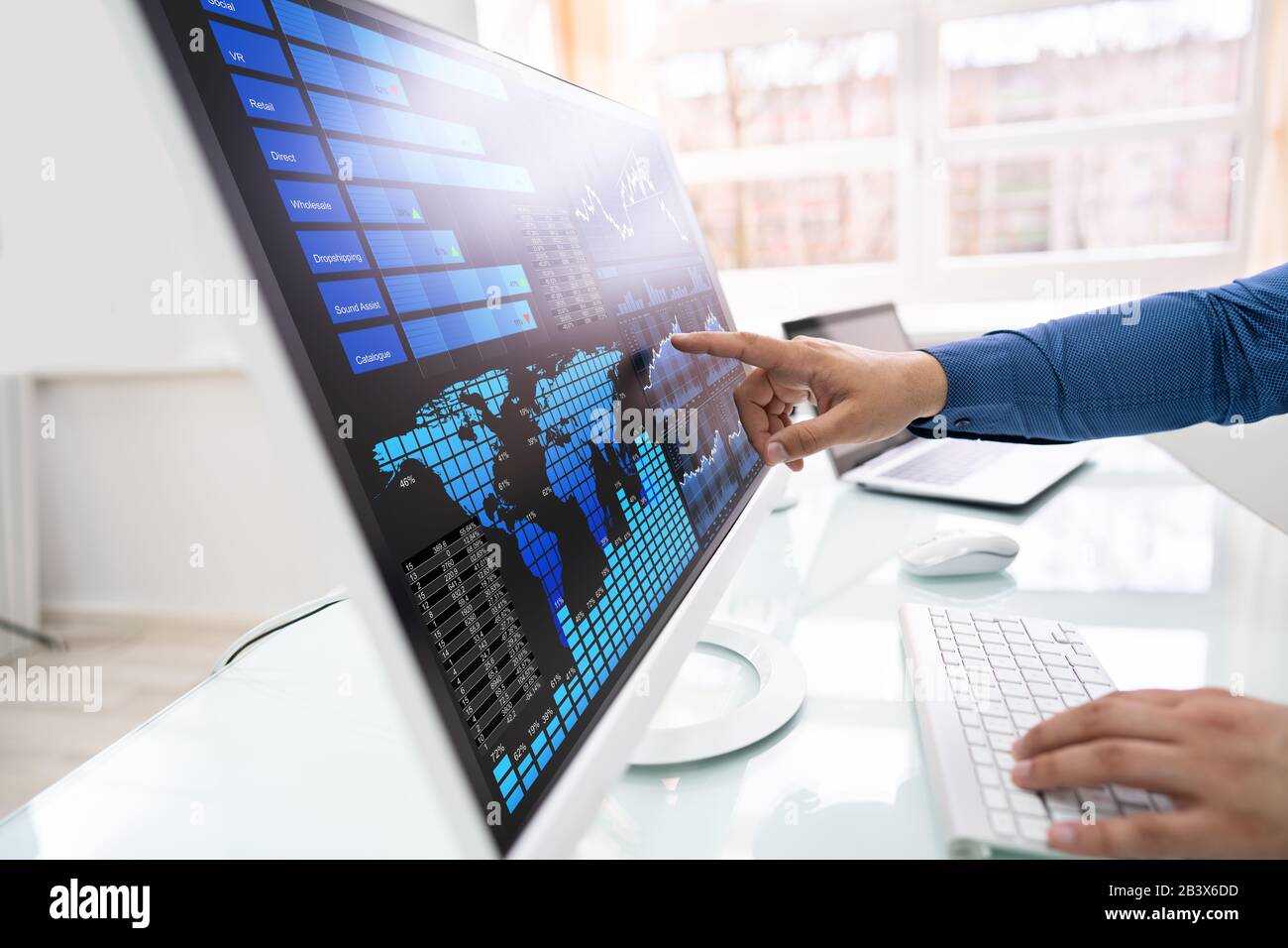 Young Businessman Analyzing Graphs On Computer At Office Stock Photo