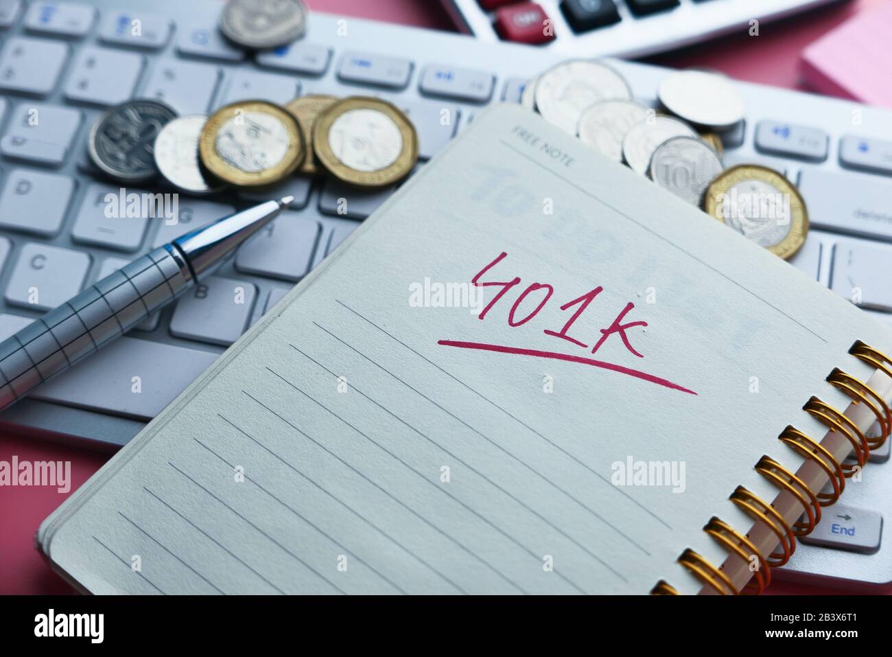 401k text on notepad with coins and keyboard on table Stock Photo