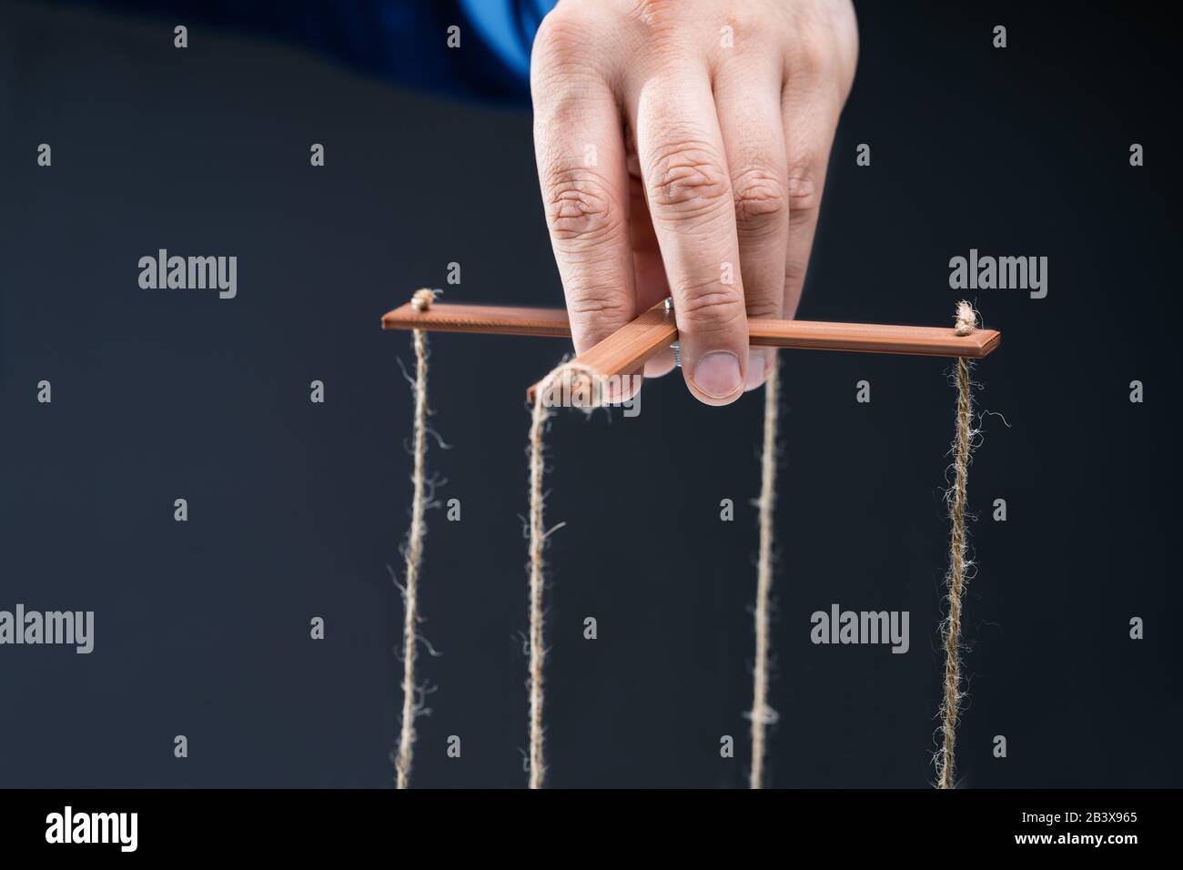 Close-up Of A Businessperson's Hand Manipulating Marionette With String Stock Photo