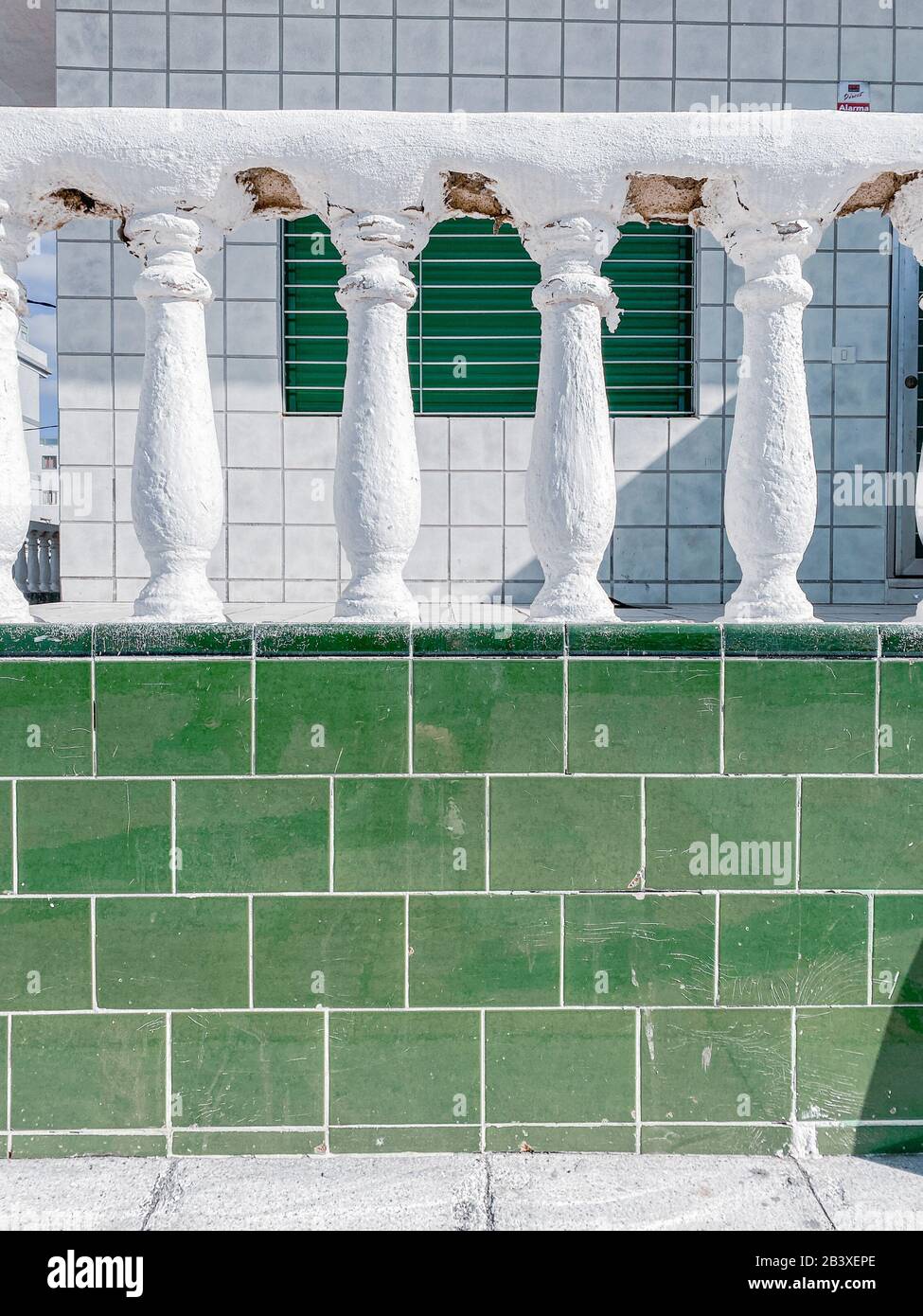 Old balustrade on the wall decorated with green tiles. Image made on mobile phone Stock Photo