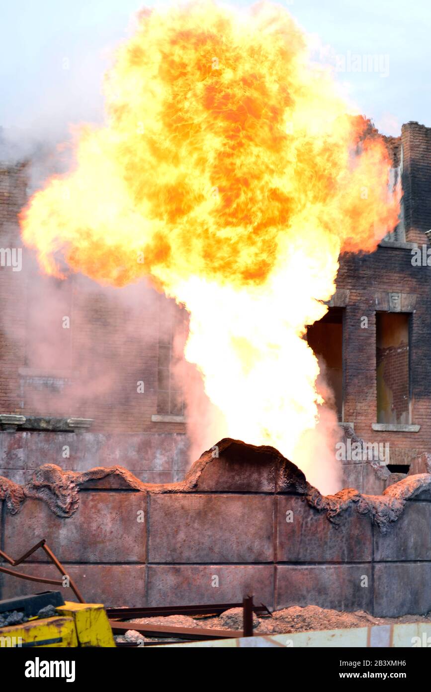 building on fire. ash, flames and smoke rise from burning apartments building. vertical image Stock Photo