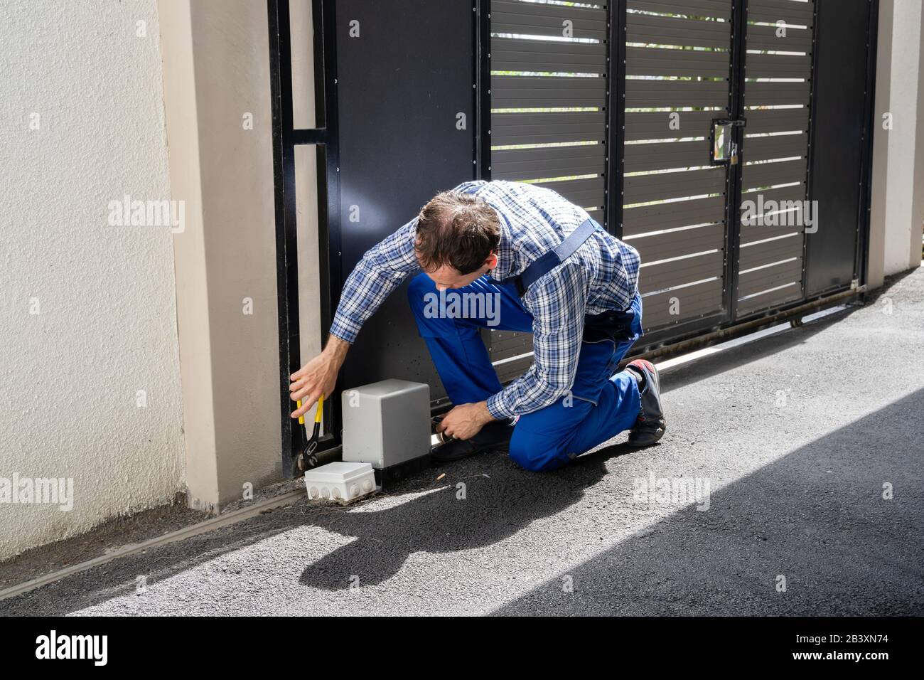 Repairman Fixing Broken Automatic Door In Building Stock Photo