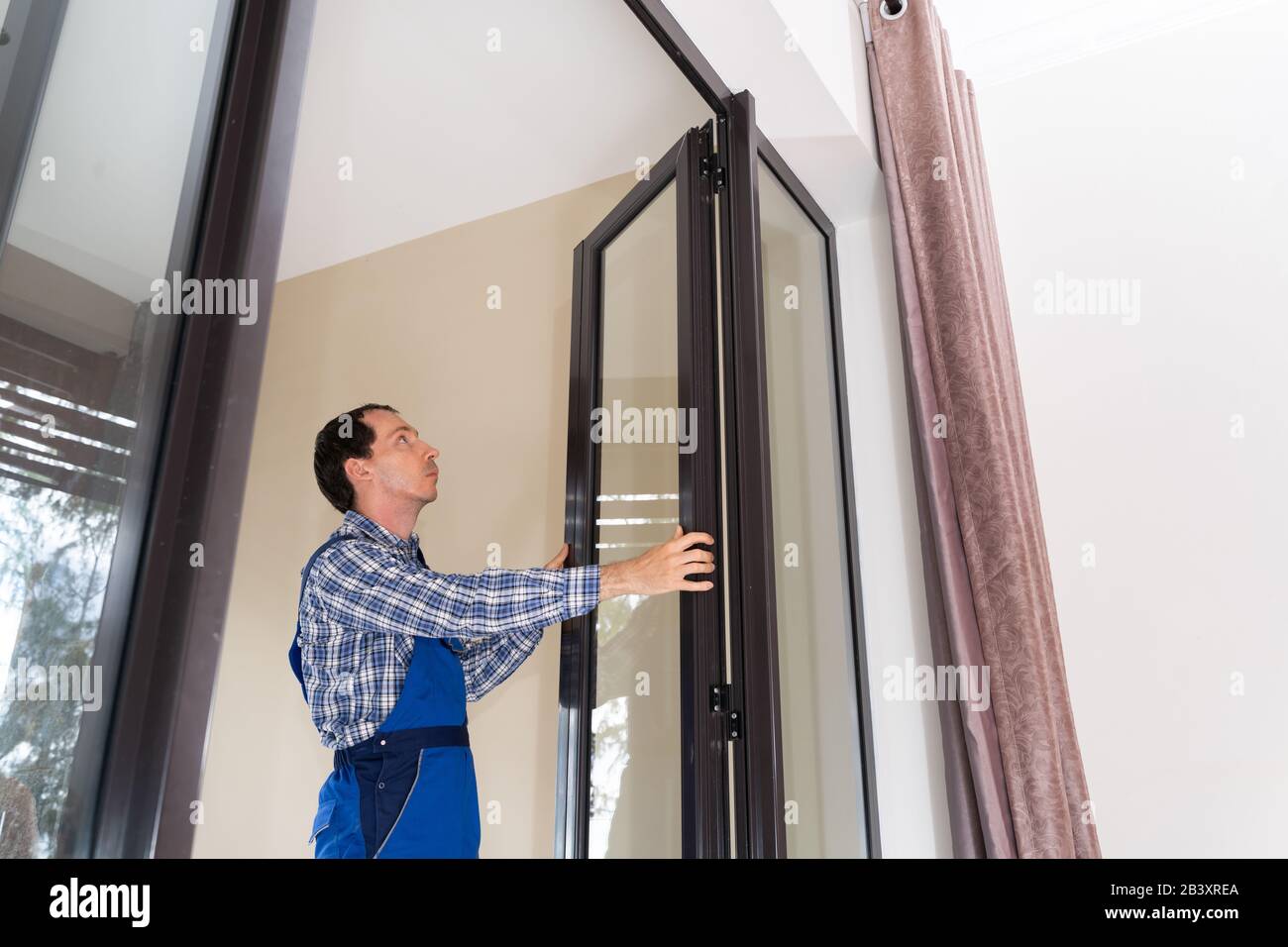 Close-up Of A Repairman's Hand Fixing Window Stock Photo