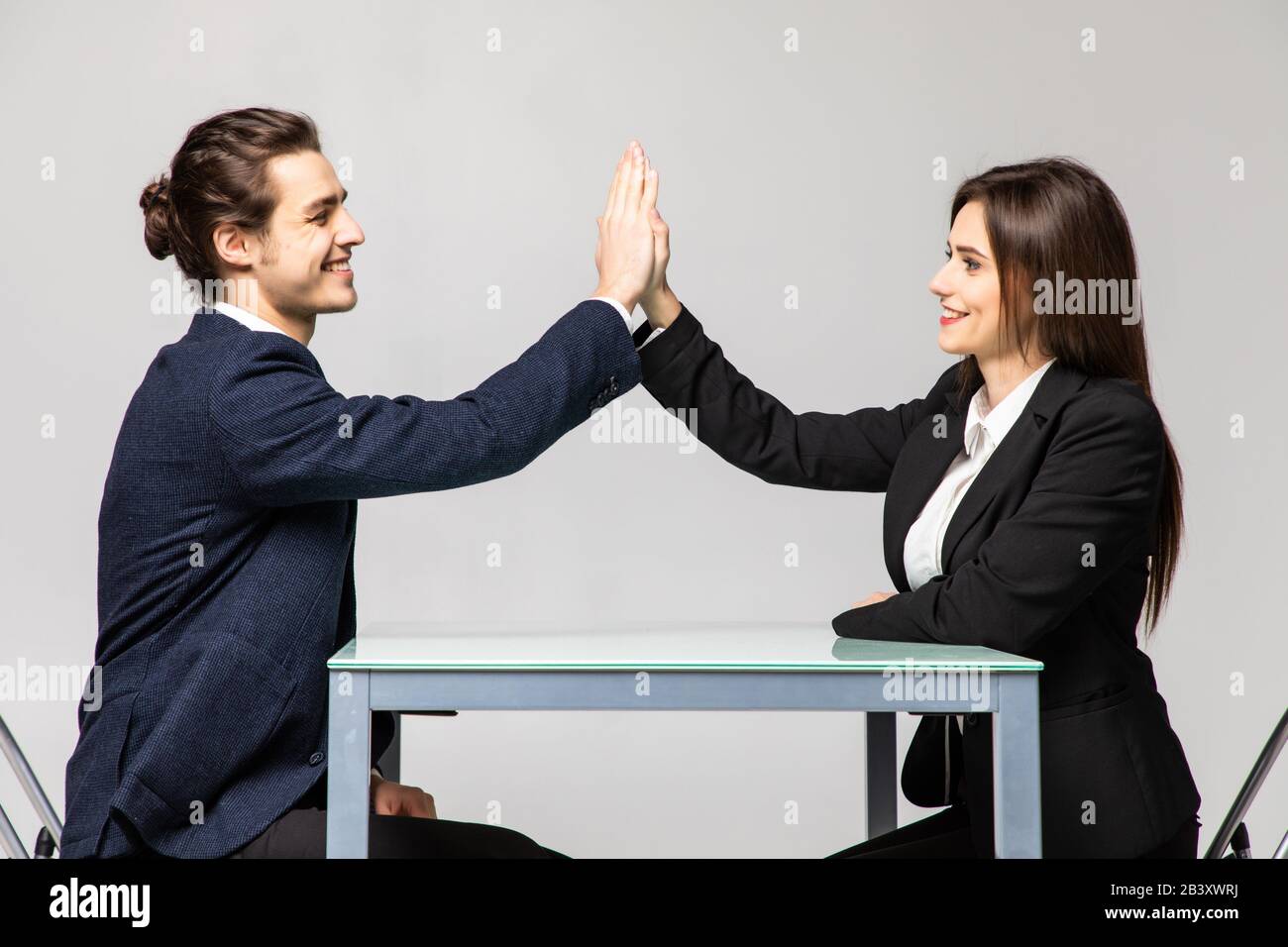 Businesspeople man and woman giving each other high five for successful ...
