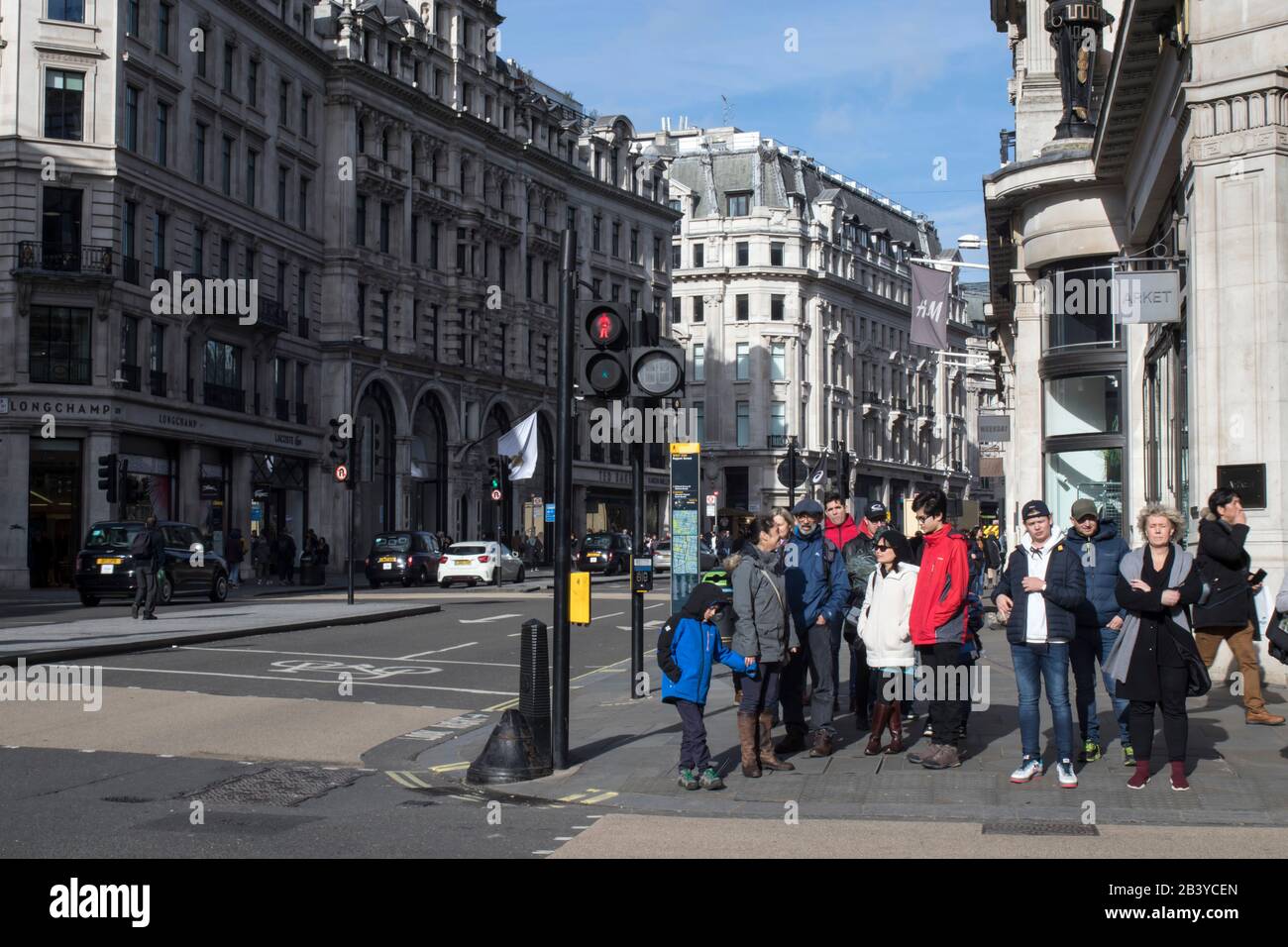 London, UK - 20 February, 2020, People waiting for the green light at a pedestrian crossing in Regent Street Stock Photo