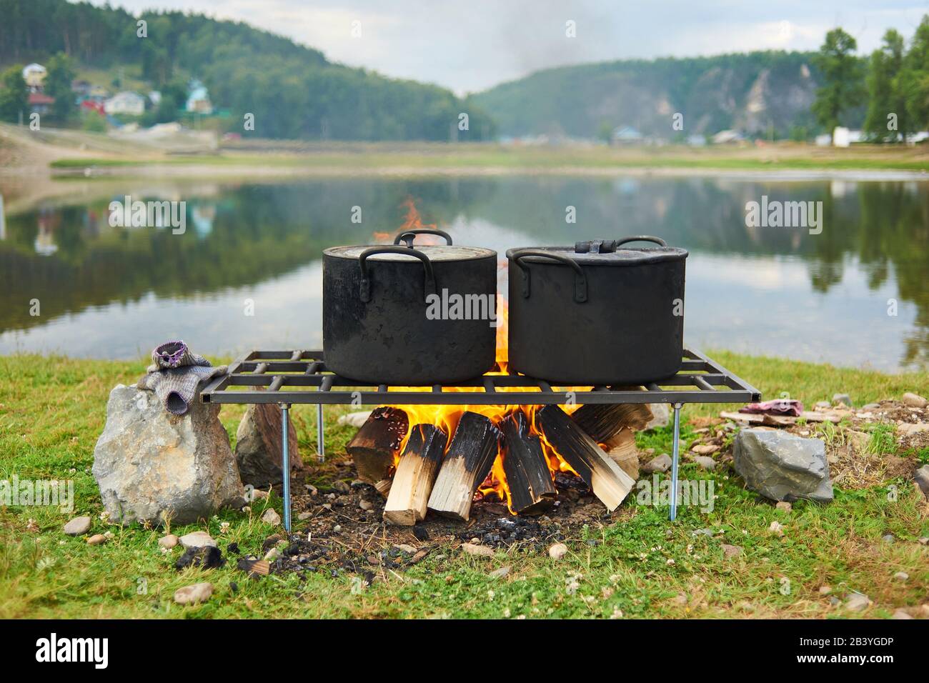 Cooking food at the stake outdoors scene, fire iron pot camping tourism,Hiking field pot, Stock Photo