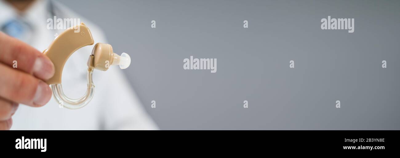 Doctor Holding Hearing Aid Device In Clinic Stock Photo Alamy